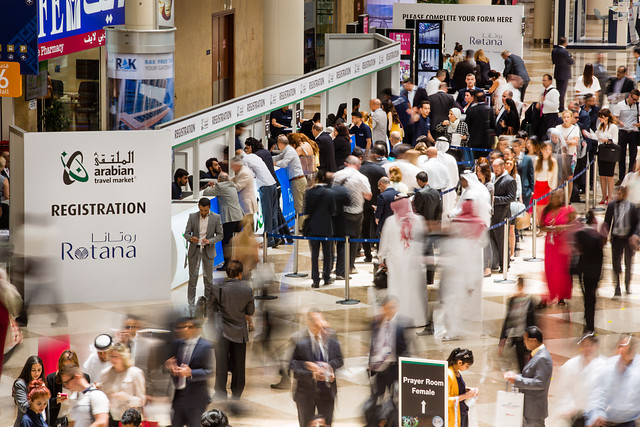 crowded registration booth for "Rotana" arabian travel market sign