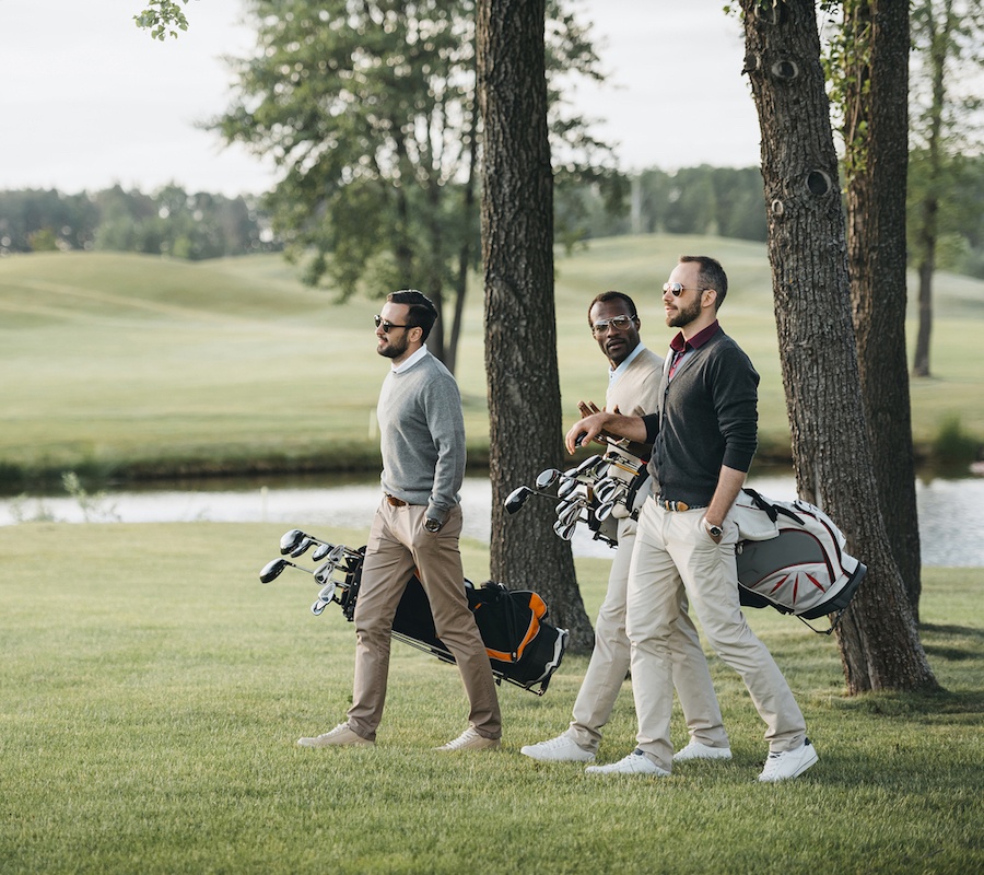 Three men walking onto the golf course together