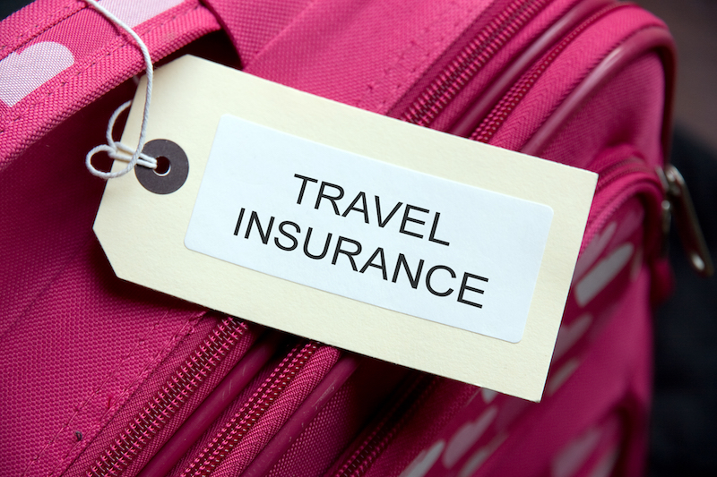 A close up picture of a luggage tag that says "Travel Insurance"