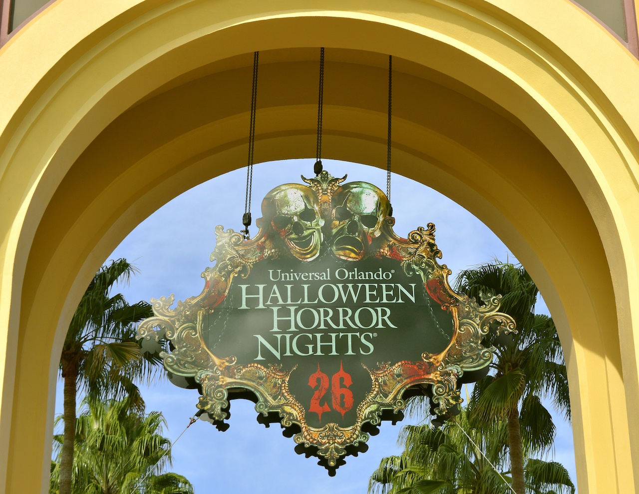 A picture of a sign in a yellow awning with skulls above that says "Universal Orlando Halloween Horror Nights 26"